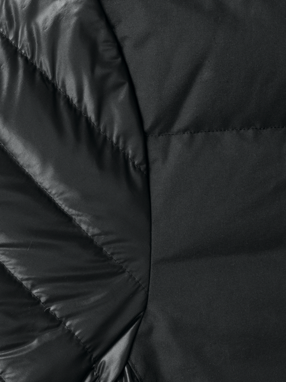 Detaljbild söm svart fodrad dunjacka med kontrasterande ok över bröstet från Texstar